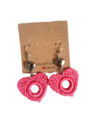 a pair of pink crochet heart earrings on a card