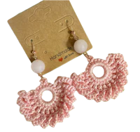 a pair of crocheted pink earrings with white beads