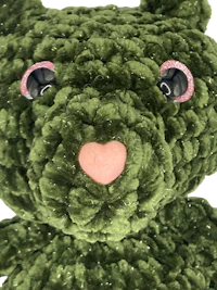 a green teddy bear with pink eyes