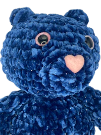 a blue teddy bear with pink eyes
