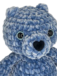 a blue teddy bear on a black background