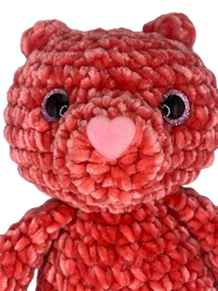 a red teddy bear with pink eyes