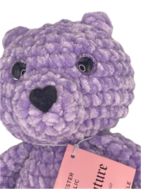 a purple teddy bear with a tag on it